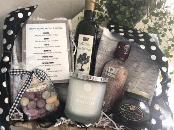 Gift basket with olive oil bottle, candle, snacks, and handwritten tag
