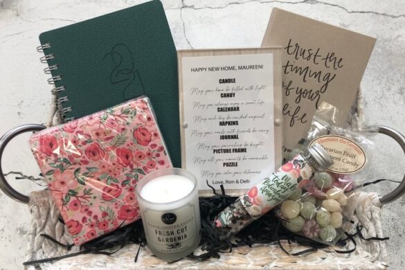 Gift basket with notebook, floral-patterned paper goods, candle, and wrapped sweets
