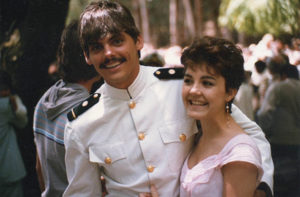 A young man dressed in a white maritime academy uniform and his young wife dressed in pink