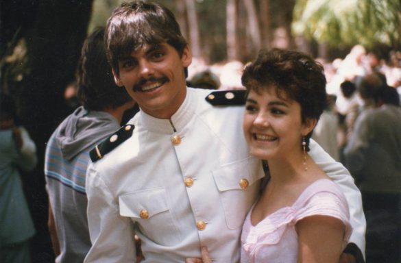 A young man dressed in a white maritime academy uniform and his young wife dressed in pink