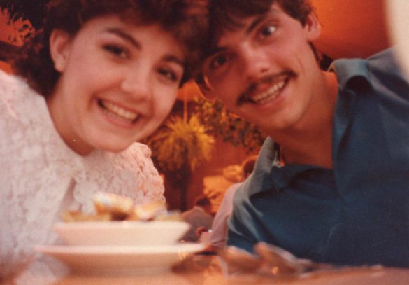 A close up young man and woman smile into the selfie on their honeymoon