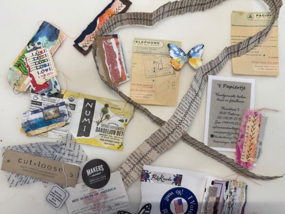 A picture of a variety of ephemera, from stamps to tea bag labels to stitched book pages to receipts.