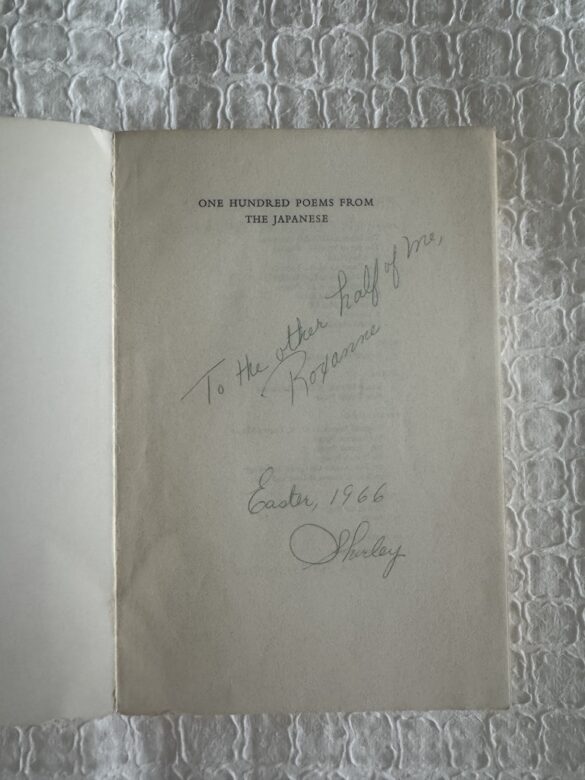 One Hundred Poems From The Japanese book is shown in a photograph. The book is opened to the first page which has a handwritten note that says: To the other half of me, Roxanne. It's signed: "Easter, 1966, Shirley