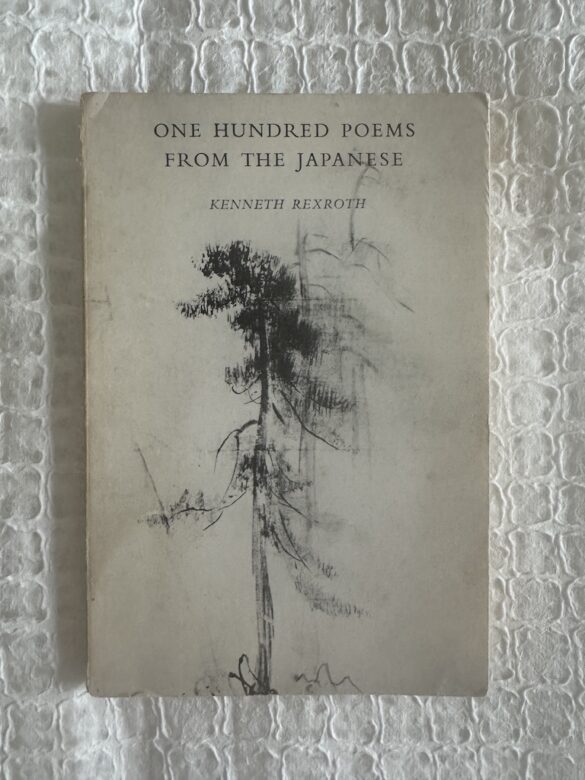 One Hundred Poems From The Japanese book is shown in a photograph. A painting of an abstract tree painted in black adorns the cover.