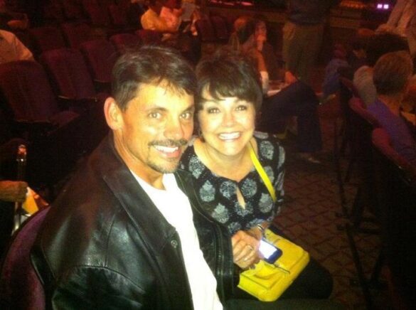 A man and a woman smile ecstatically while seated in a theater waiting for the show to begin.