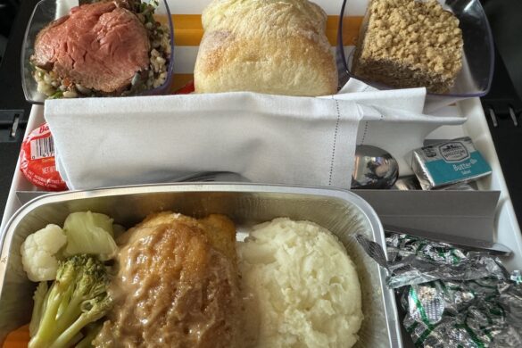 Condor Airlines premium seat dinner with chicken, rice, vegetables, salad, and fresh bread, part of 33 Days in Europe