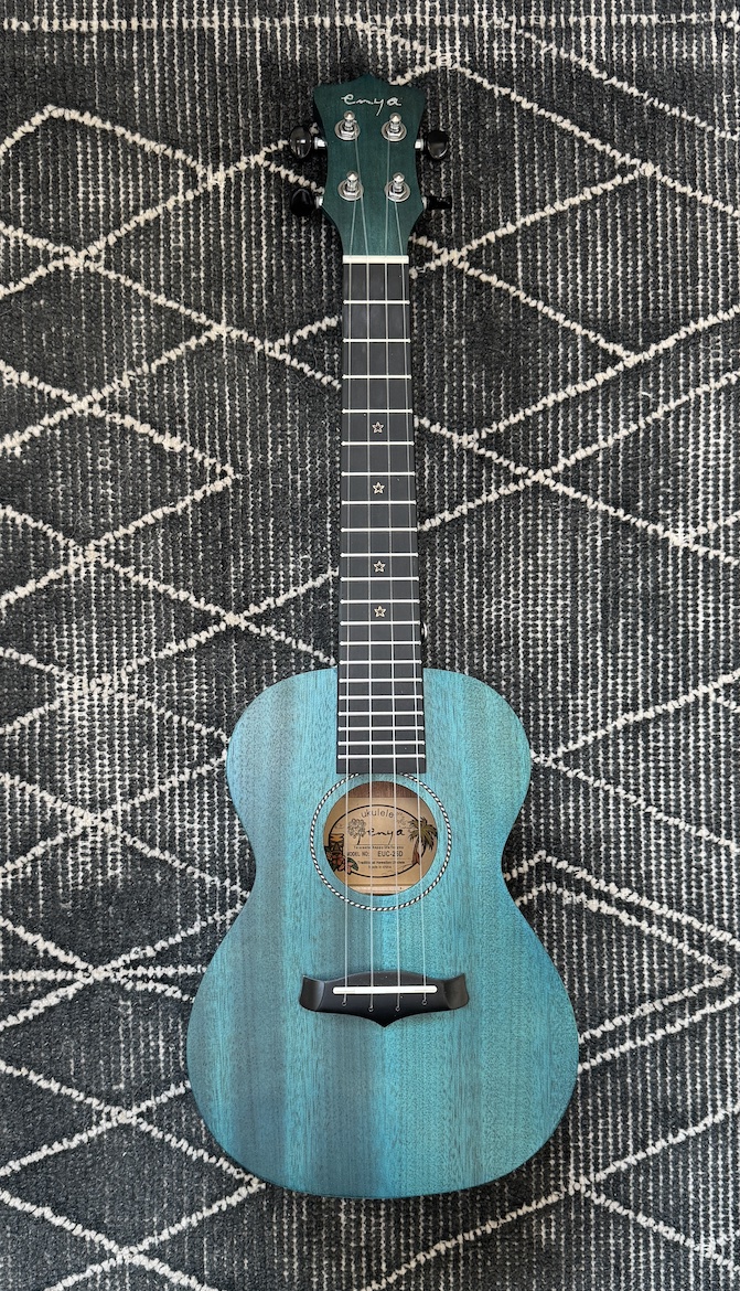Blue ukulele on patterned black-and-white rug