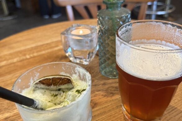 Spicy matcha drink and amber beer on wooden table at Wirtshaus Krienbrüggli, Lucerne.