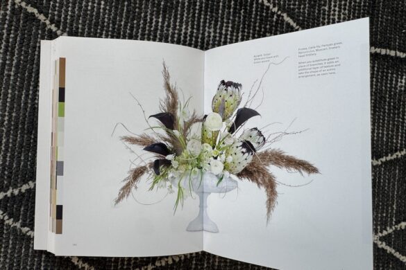 Book spread showing a neutral floral arrangement in brown, black, and white, Flower Color Theory, page 144.