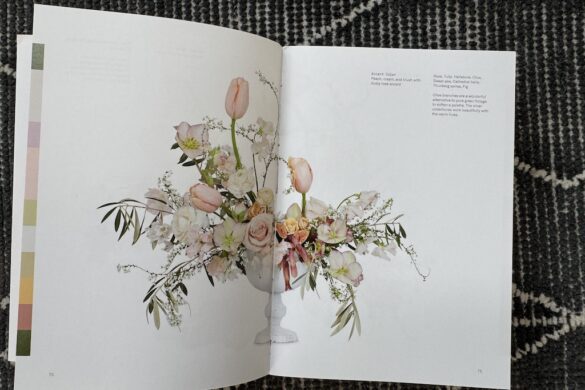 Floral arrangement in a white urn with tulips, roses, hellebores, sweet peas, olive branches, ranunculus, thunbergia, and figs in peach, cream, and blush tones, from Flower Color Theory, page 70.