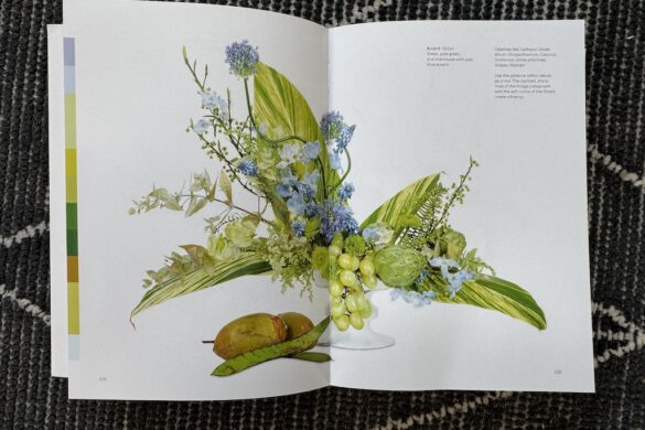 Book spread showing a floral arrangement in green, pale green, and chartreuse with pale blue accent, Flower Color Theory, page 124.