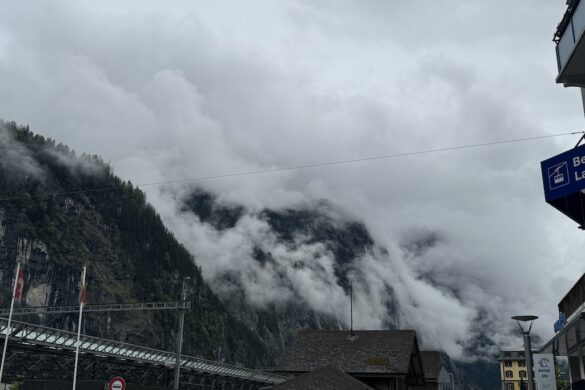 Misty clouds moving between steep green cliffs in Lauterbrunnen Valley, Switzerland