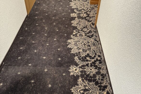 Interior hotel hallway with patterned carpet, wood doors, and ceiling lights at Hotel Silberhorn in Lauterbrunnen, Switzerland