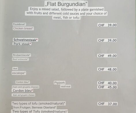 Smartphone screen showing a restaurant menu translated from German to English with Google Lens; items include “Burgundy Teller” mixed salad with choice of chicken, pork steak, beef entrecôte, veal escalope, cordon bleu, or tofu.