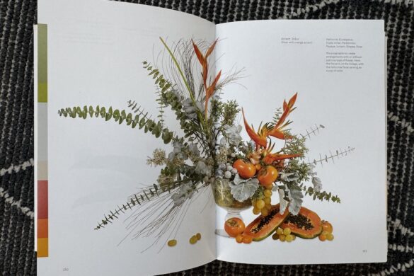 Book spread showing a floral arrangement in orange with gray and green accent, Flower Color Theory, page 150.
