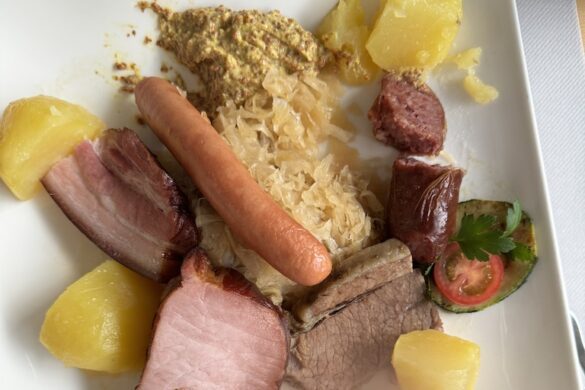 Plate with ham, sausage, potatoes, sauerkraut, and vegetables served at Lucerne restaurant, Silberhorn