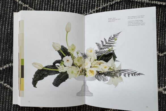 Book spread showing a floral arrangement in white with green accent, Flower Color Theory, page 130.