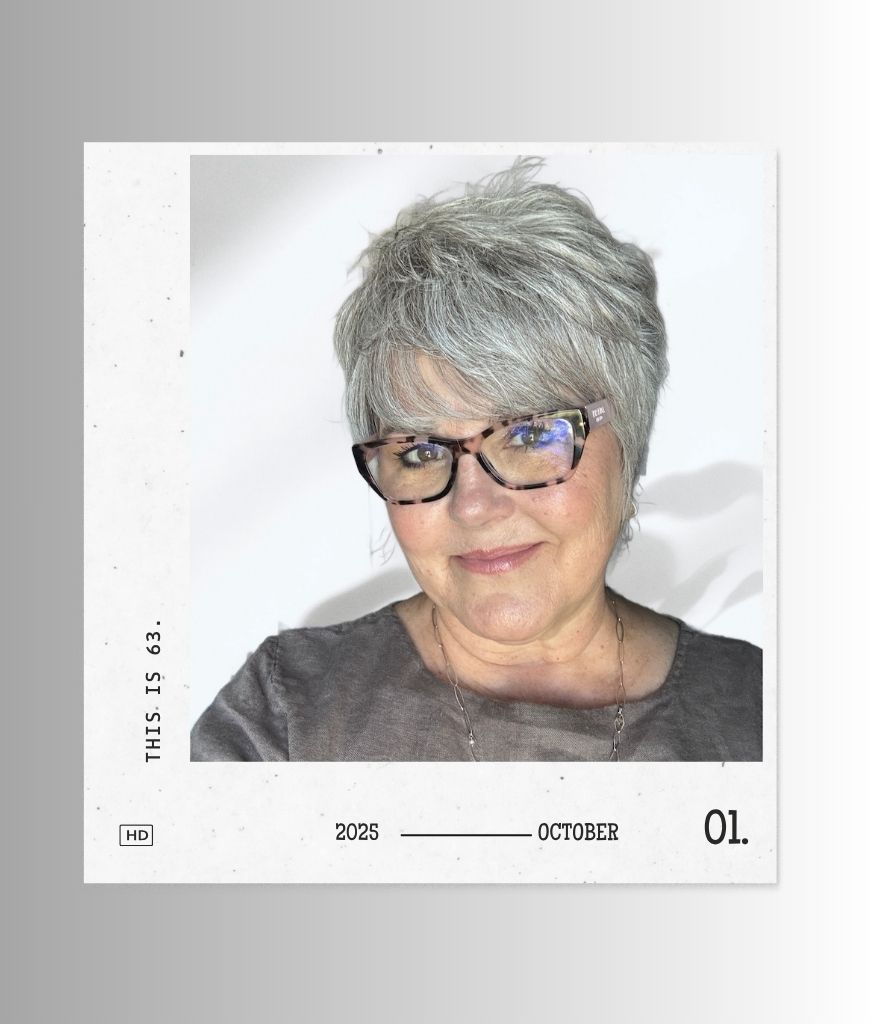Deborah Bass portrait with glasses and short gray hair, framed with white space and subtle shadow