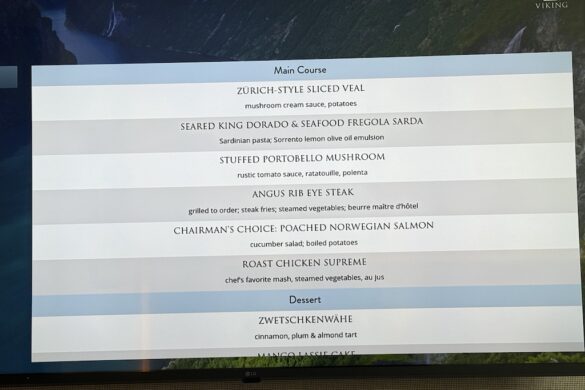 Digital display aboard Viking Alruna showing the first night’s dinner menu with entrée and dessert options including veal, salmon, steak, chicken, and tart.