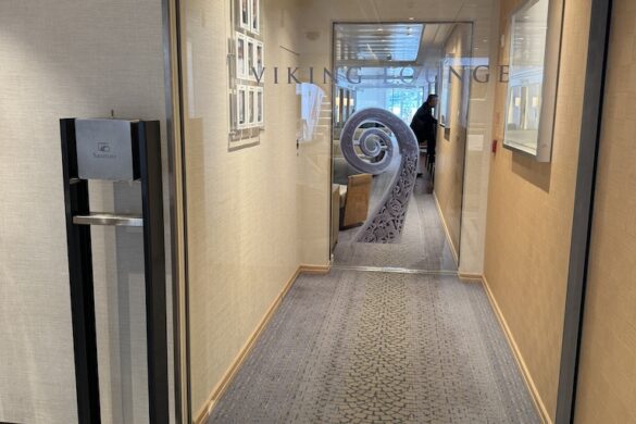 Glass doors leading into the lounge and dining area aboard the Viking River Cruise Alruna, with warm wood finishes and soft lighting inside