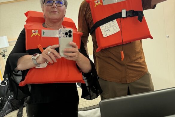 Deborah and Ron wearing orange safety vests during the mandatory safety exercise in their Viking Alruna stateroom