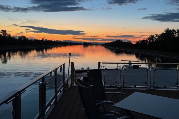 Sunset over the Rhine River viewed from the deck of the Viking Alruna, with orange and blue skies reflected on the water