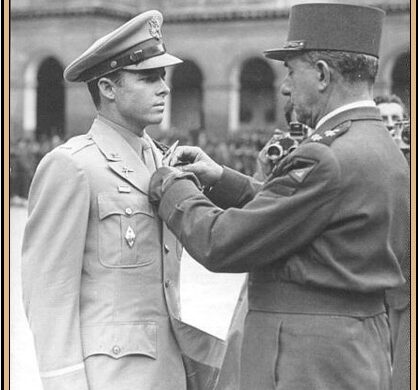 Audie Murphy in military uniform receiving the French Legion of Honor medal from an officer in 1948.
