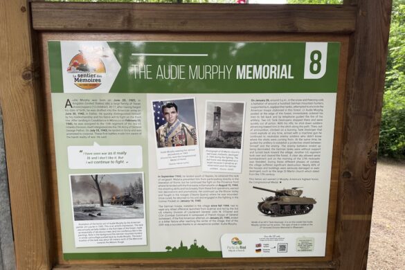 Stone wall featuring a tank silhouette with American and French flags at the Audie Murphy Memorial.