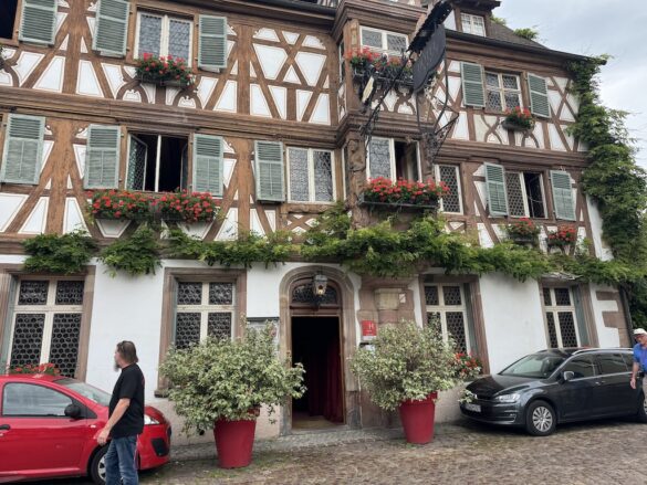 Traditional half-timbered buildings with window boxes and flowers in Colmar, France.