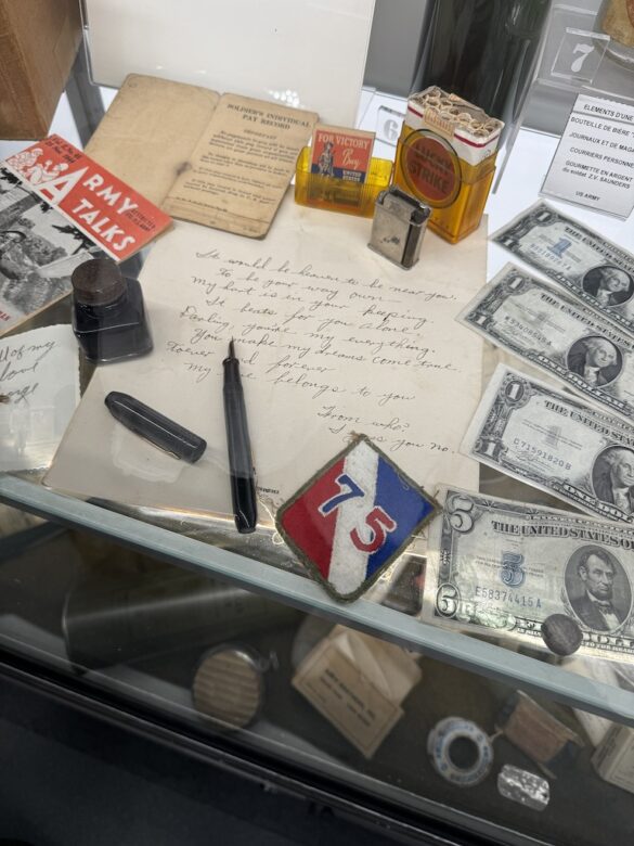 Display case with wartime letters, ration tickets, and currency at the Colmar Pocket Memorial Museum.