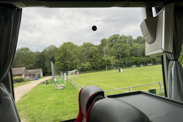 Children playing sports on a green field near the Audie Murphy Memorial in Holtzwihr, France.