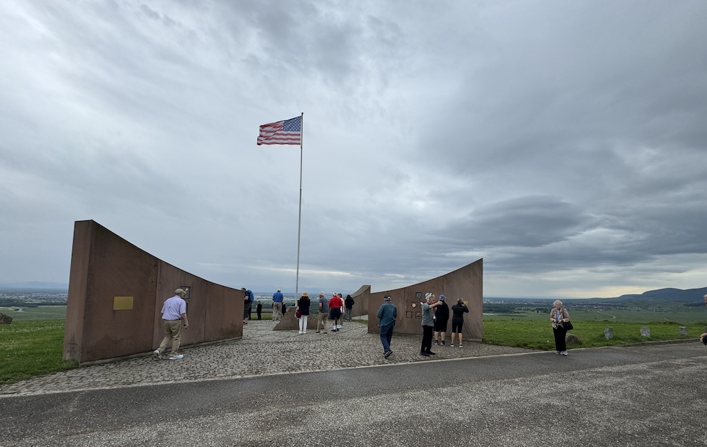 Monument National des Combats de la Poche de Colmar on Mont de Sigolsheim, with French and American flags flying above the vineyards of Alsace.