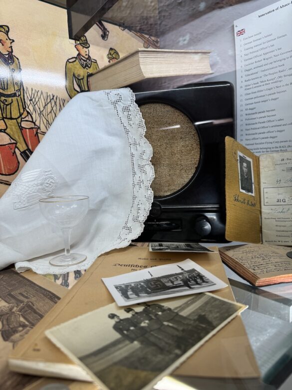 Museum display with crystal glass, lace doily, small radio, and copy of Mein Kampf from Hitler’s Eagle’s Nest.
