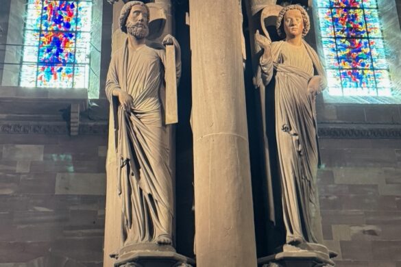 Tall stone columns with stained glass windows inside Strasbourg Cathedral
