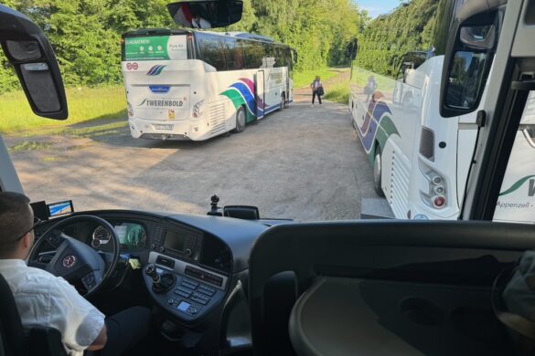 View through a tour bus windshield showing a road and traffic near Strasbourg