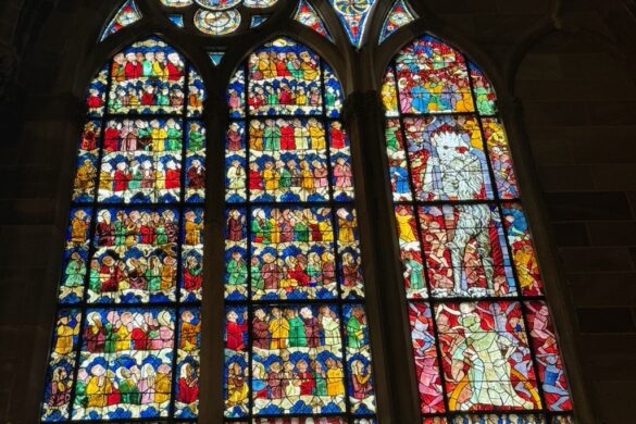 Stained glass window with colorful geometric and figurative designs