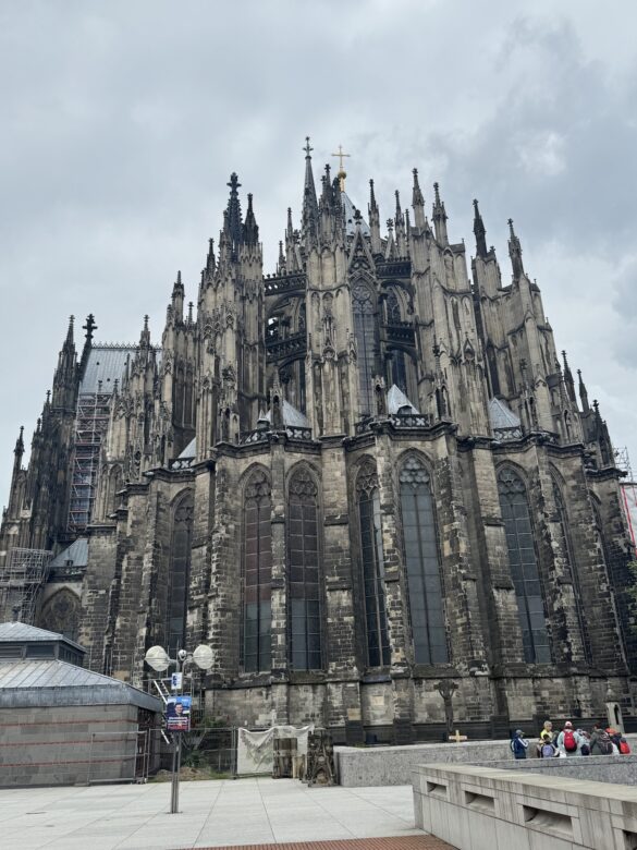 Wide view of Cologne Cathedral showing Gothic flying buttresses and tall stained glass windows