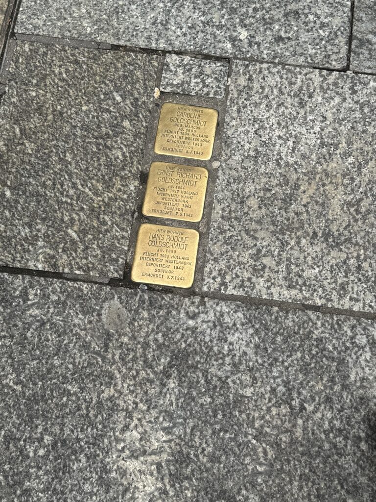 Three Stolpersteine memorial stones for Caroline, Ernst Richard, and Hans Rudolf Goldschmidt set into a sidewalk in Cologne, Germany