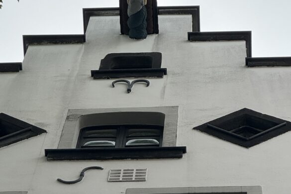 Stepped gable of the 16th-century Delfter Haus with hoisting beam and decorative figure in Cologne, Germany