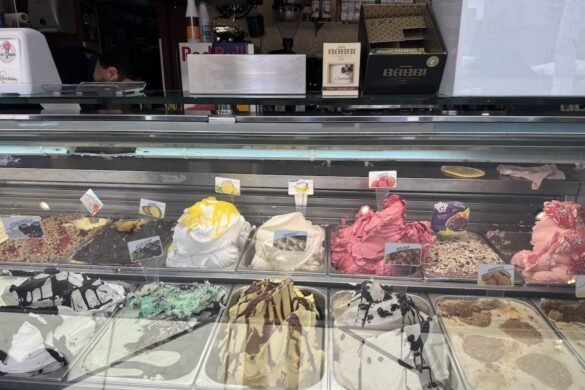 colorful gelato flavors displayed in a glass ice cream case at a café counter