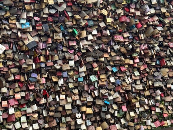 Dense cluster of colorful love locks attached to the Hohenzollern Bridge railing in Cologne, Germany