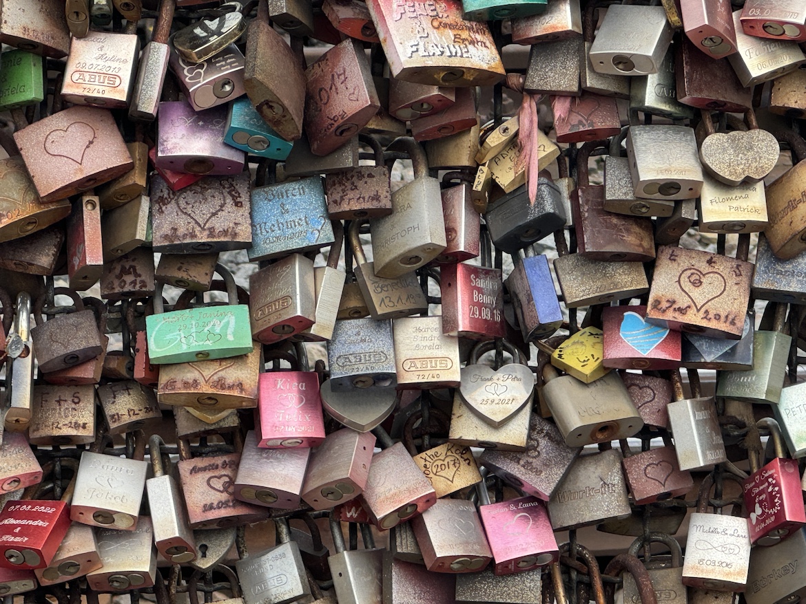 Close-up of colorful love locks attached to the Hohenzollern Bridge railing in Cologne, Germany