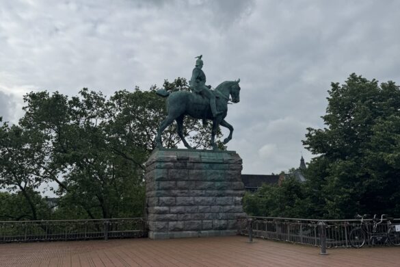 Equestrian statue of Kaiser Wilhelm I on a stone pedestal near the Rhine River in Cologne, Germany