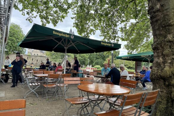 outdoor beer garden tables under trees along the Rhine River