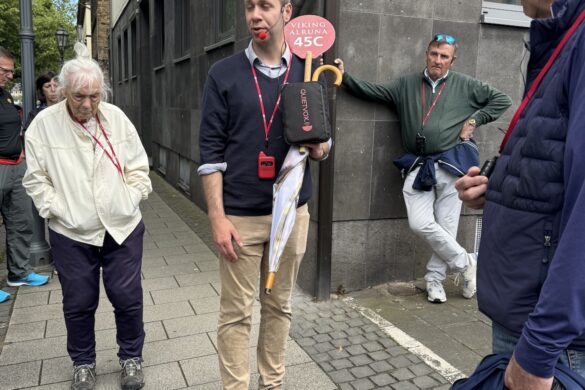 Walking tour guide speaking to a small group on a sidewalk in Koblenz.