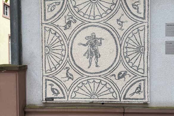 rectangular Roman mosaic mounted on a wall showing Hercules in the center surrounded by birds and geometric patterns