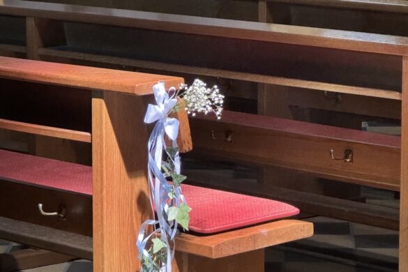 wooden church pews and lectern with white floral arrangement inside St. Castor Basilica