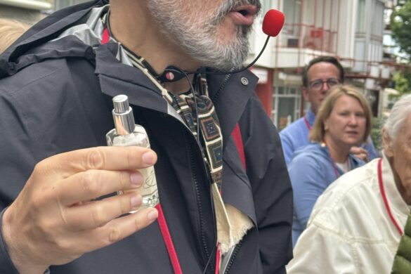 Viking River Cruise guide holding a small bottle of eau de cologne during a walking tour in Cologne, Germany