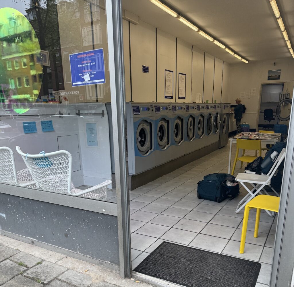 clean laundromat interior in amsterdam with rows of washing machines and tiled floor