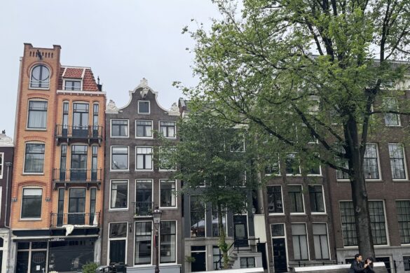 historic canal houses and street scene along a canal in amsterdam